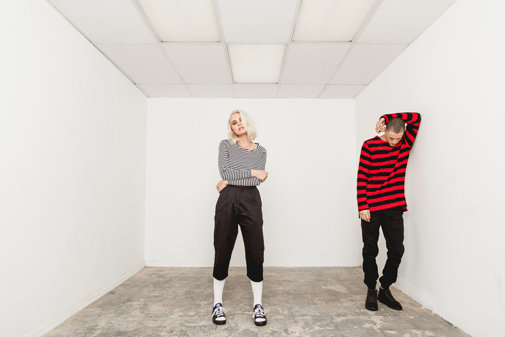 Publish — dámské černo-bílé pruhované tričko — černé tříčtvrteční kalhoty — pánské černo-červené tričko s pruhy — černé kalhoty joggers — His and Hers — lookbook — pánské oblečení, dámské oblečení
