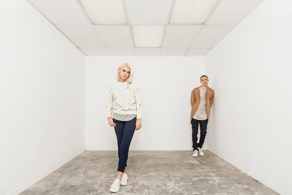 Publish — dámská smetovaná mikina s potiskem — modré skinny fit kalhoty po kotníky — pánská dlouhá bunda, béžová, hnědá — černé kalhoty — His and Hers — lookbook — pánské oblečení, dámské oblečení