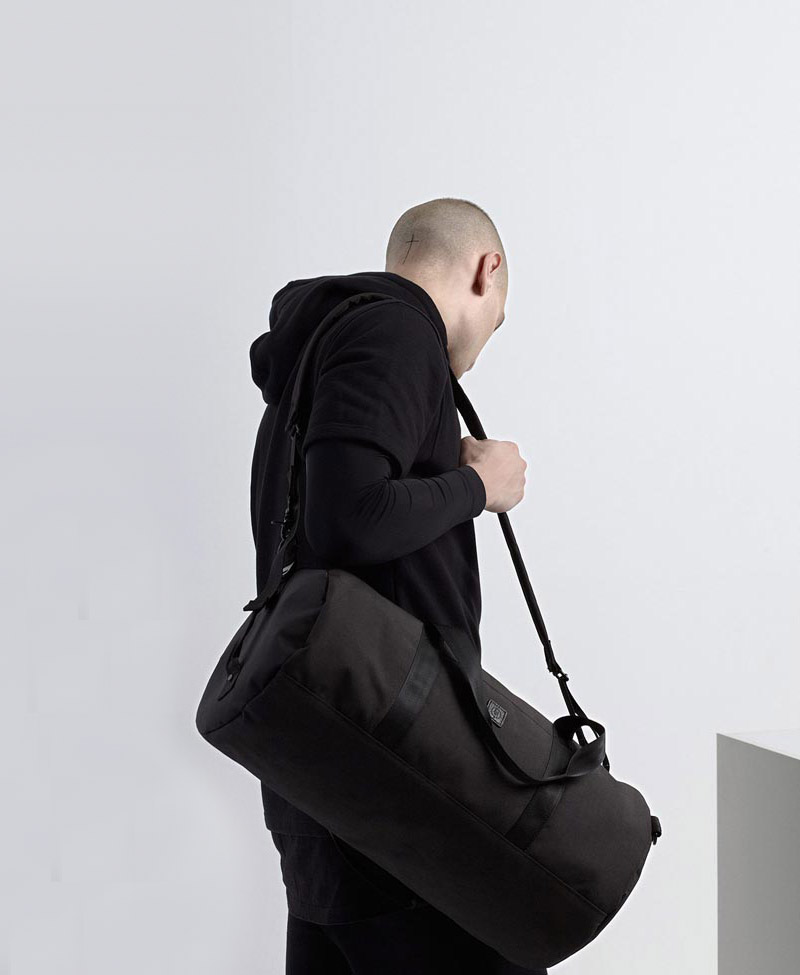 Ucon Acrobatics — černá cestovní taška přes rameno — na záda — válcový tvar
