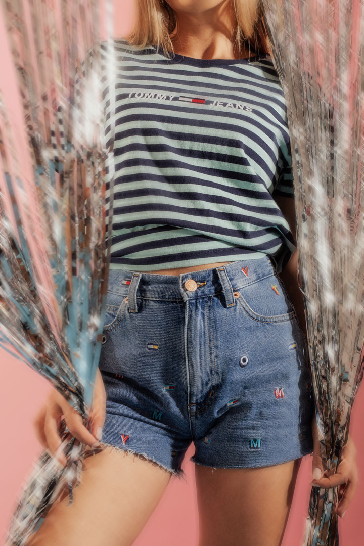 Tommy Jeans x Queens — lookbook — dámské džínové kraťasy — zeleno-modré proužkované tričko s výšivkou